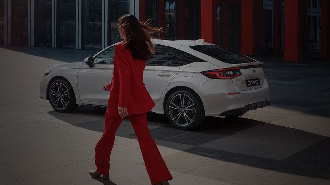 Une dame s'approche d'une Civic hybride