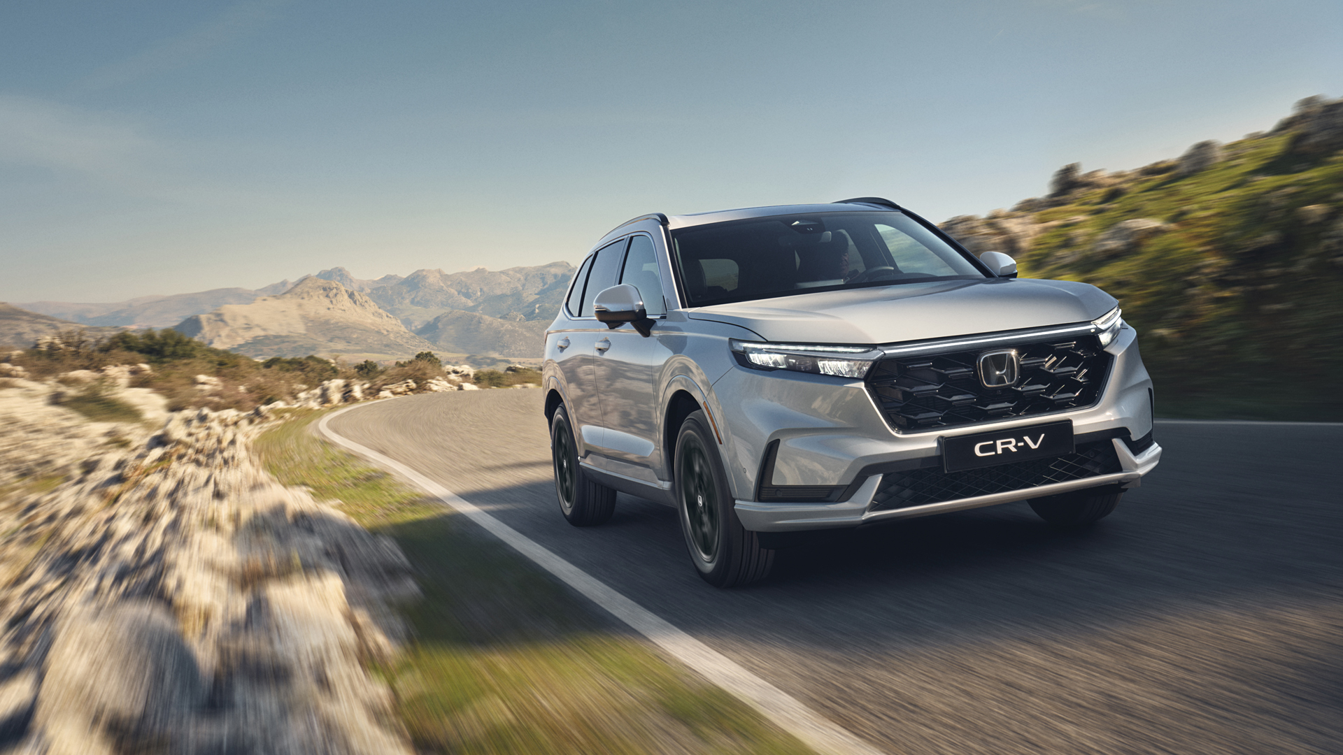Un SUV CR-V hybride rechargeable circulant sur une route de montagne.