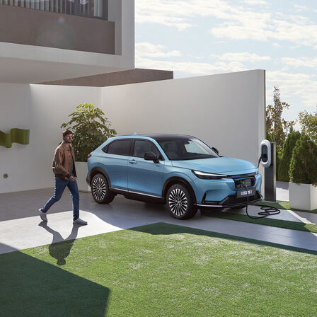 Honda e:Ny1 en charge devant la maison.