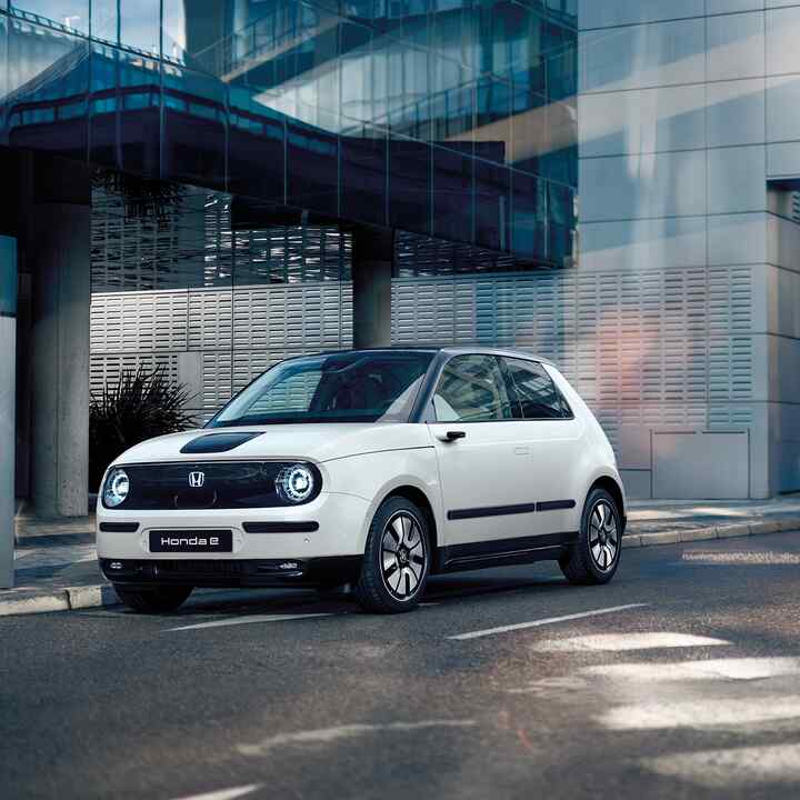 Honda e dans la rue avec des bâtiments en arrière-plan