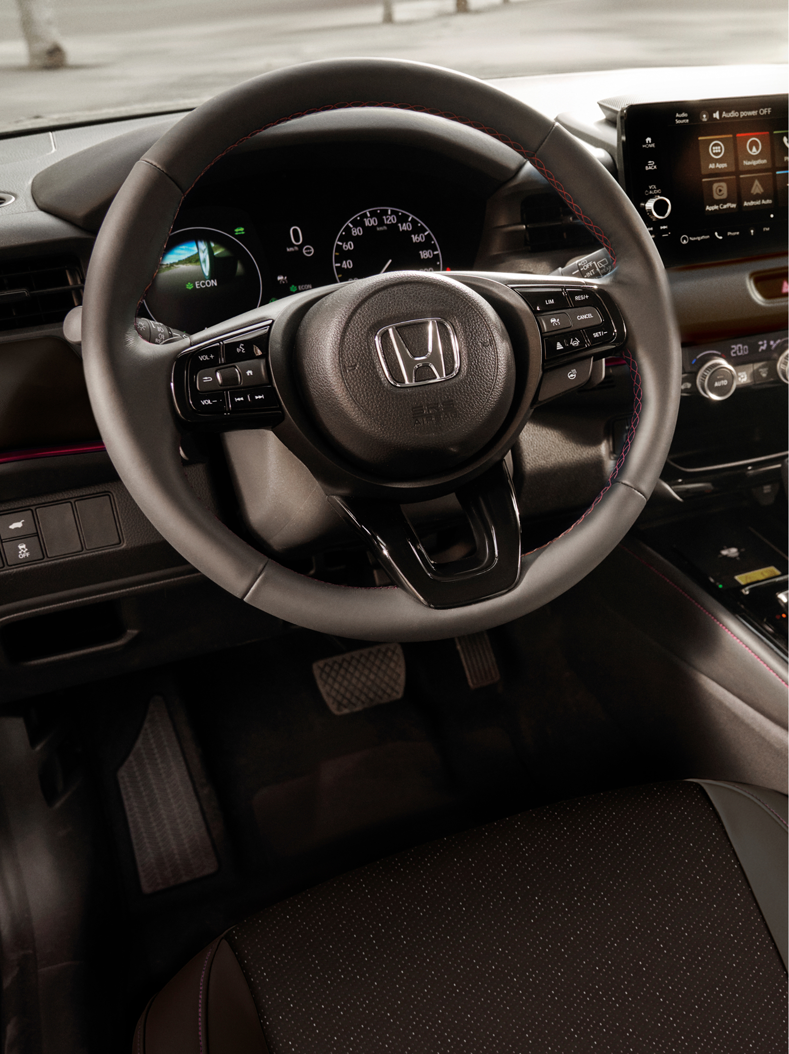 Vue de l’habitacle d’un Honda HR-V montrant le volant, le combiné d’instruments numérique, l’écran tactile central et le sélecteur de vitesses automatique.