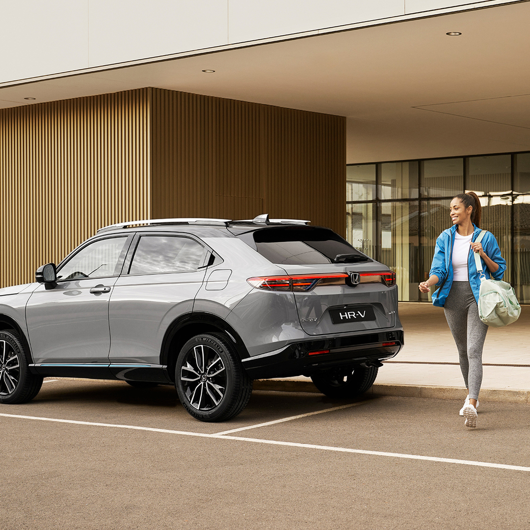 Femme passant devant un HR-V en stationnement.