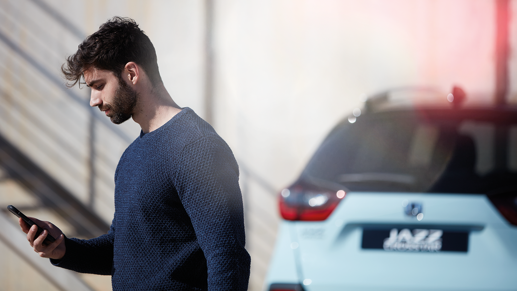 My Honda+ App close up of person using phone outside of car