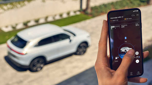 Une propriétaire d'une Honda utilise l'application My Honda+ sur son téléphone