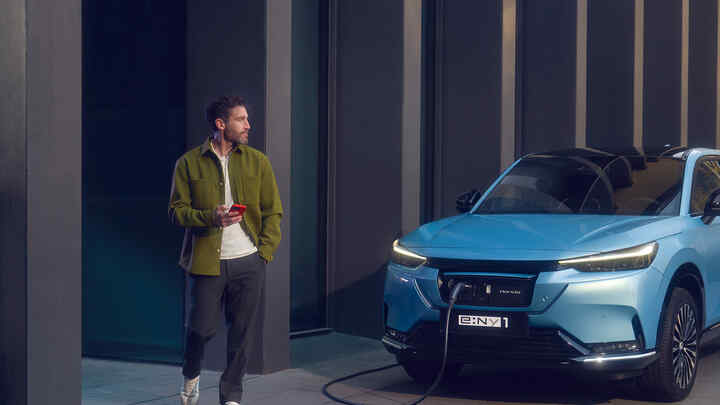 Honda e:Ny1 et Honda e circulant devant un parc éolien. 