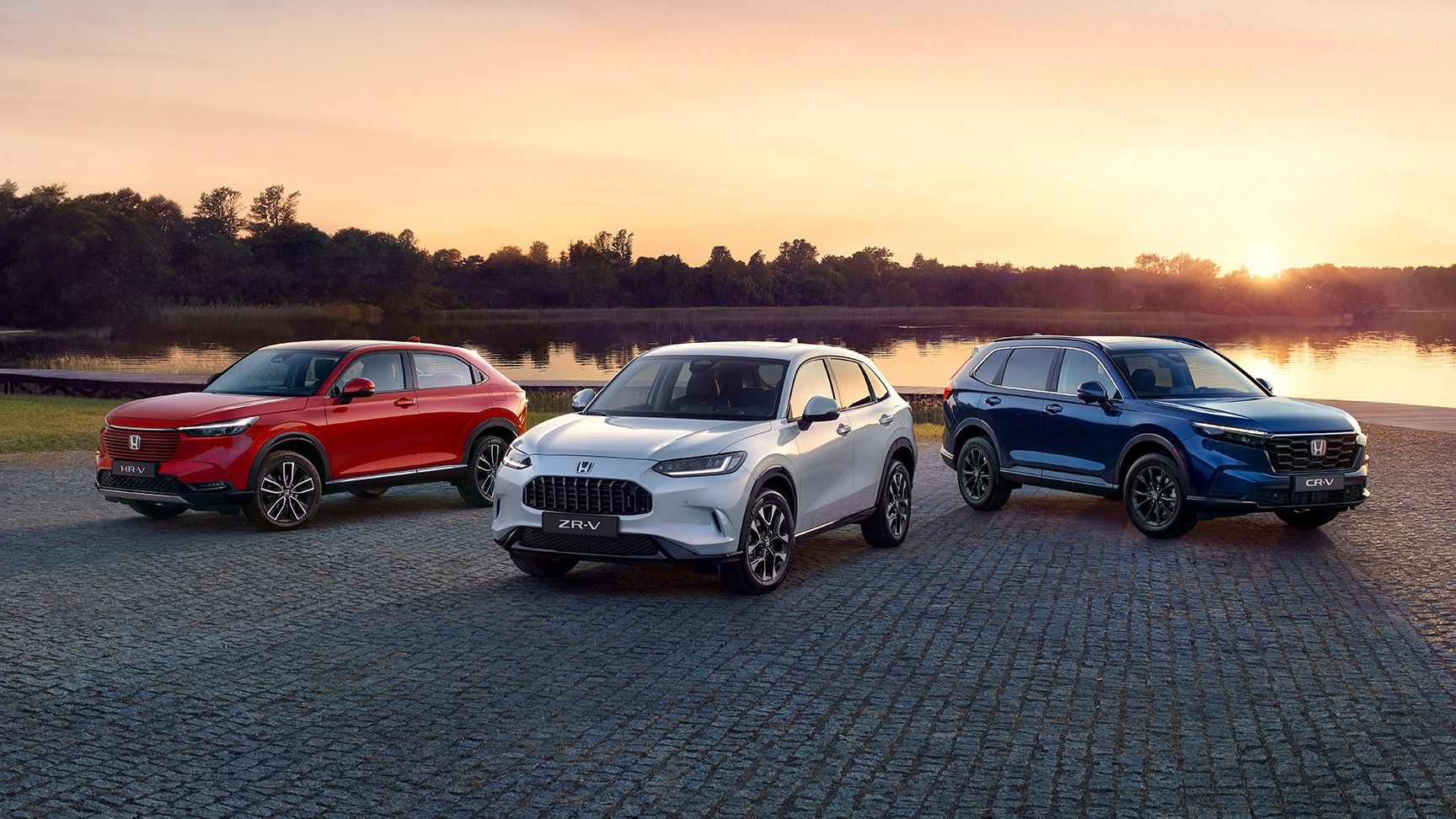 Gamme de véhicules hybrides Honda garés devant un paysage urbain