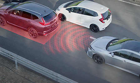 Cliché extérieur d'un véhicule à technologie Honda Sensing dans un embouteillage, avec mise en valeur du régulateur de vitesse adaptatif.