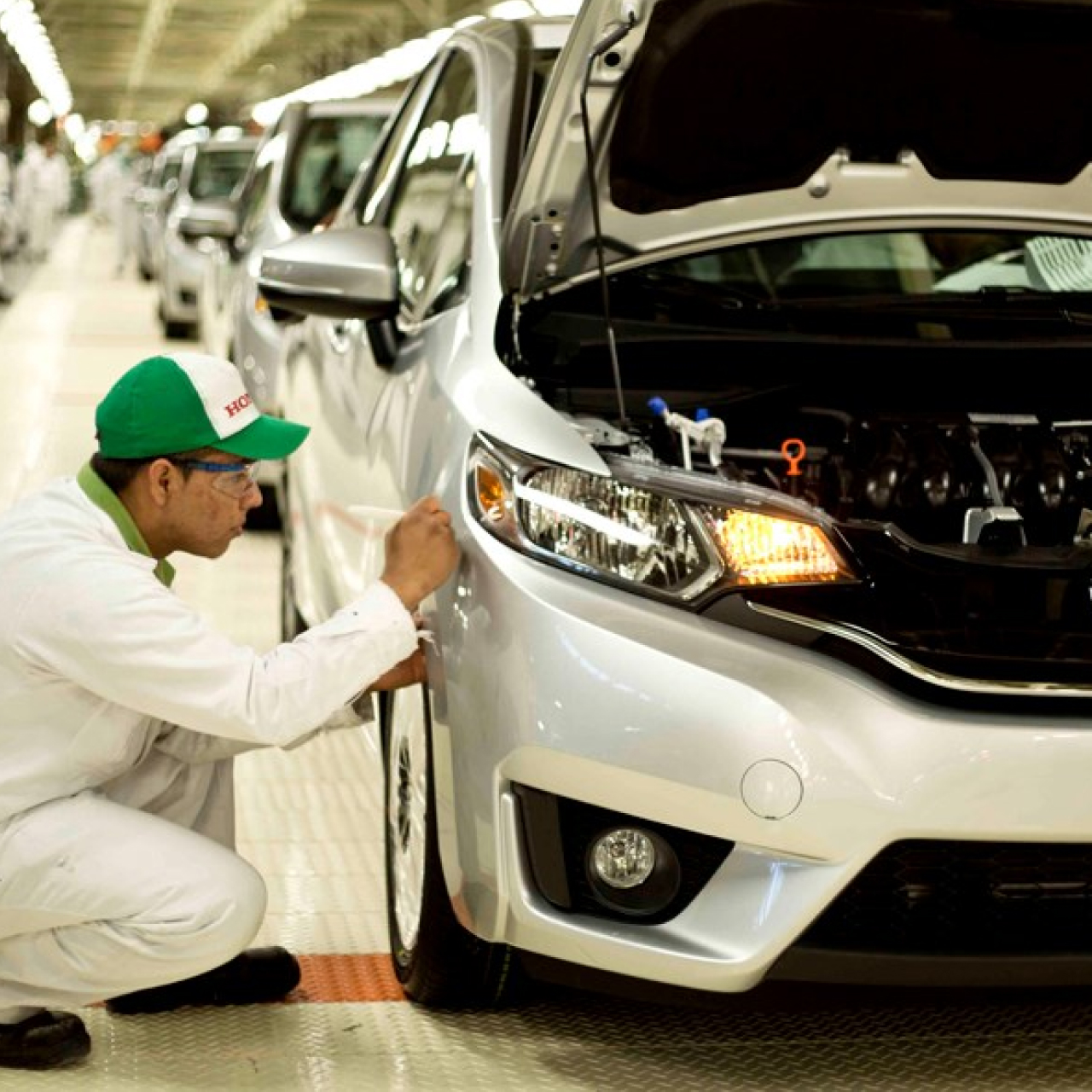 Technicien Honda travaillant sur une voiture à l'usine.