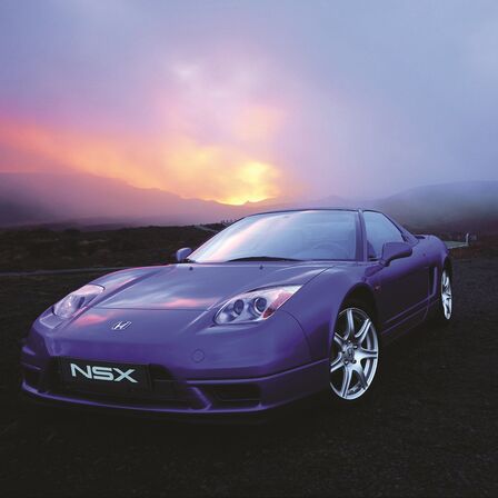 Vue de trois quarts face de la Honda NSX au coucher du soleil.