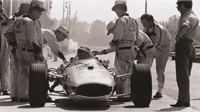 Vue avant de la voiture de Formule 1 Honda des années 1960 avec pilote et ingénieurs.