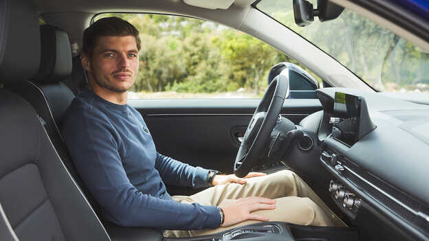 Max Verstappen assis à l'intérieur du SUV hybride ZR-V dans un parc.