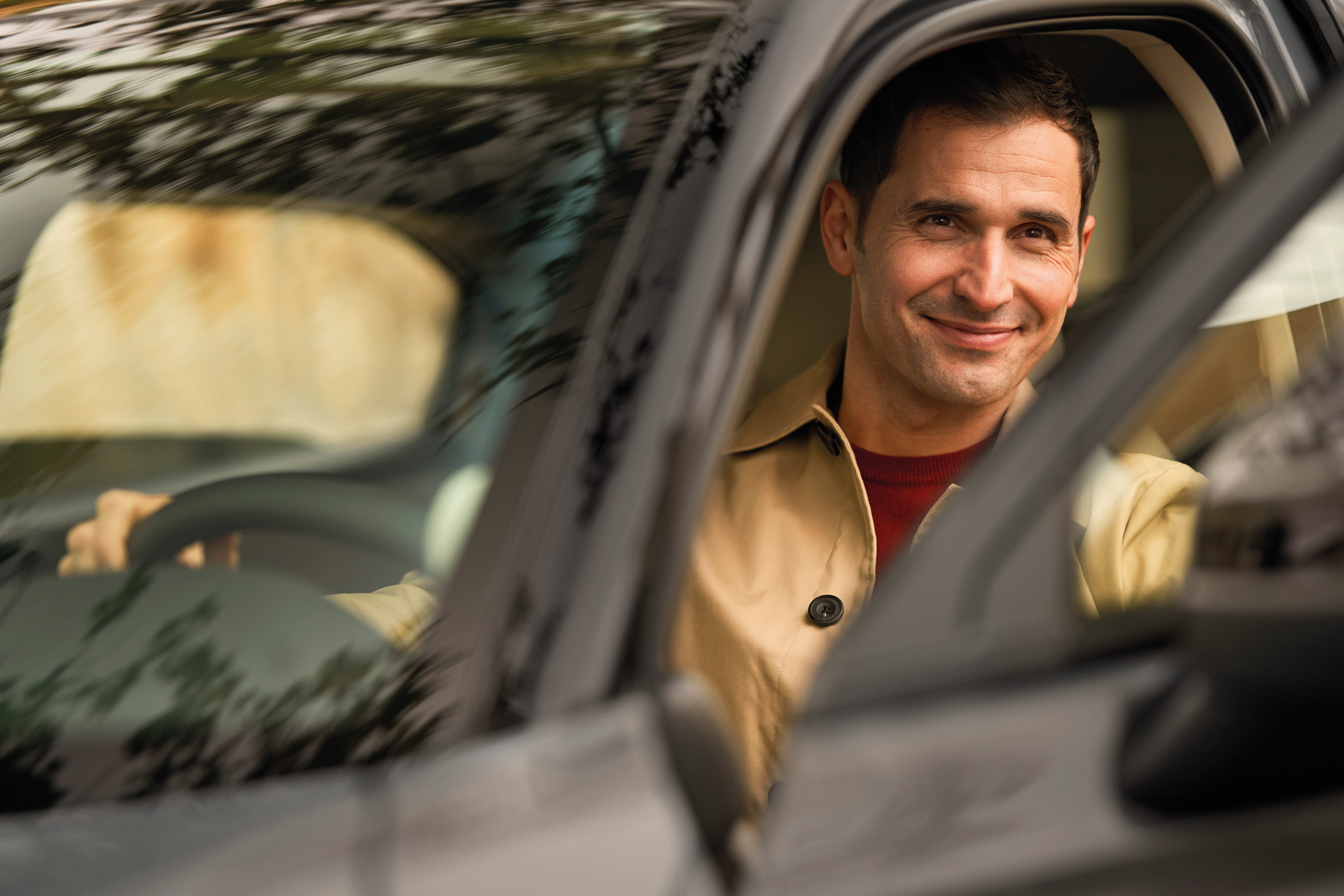 Un homme souriant au volant d'une voiture Honda