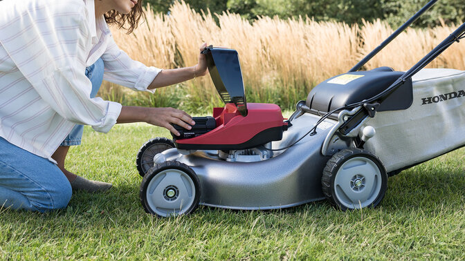 Femme utilisant un souffleur dans un jardin