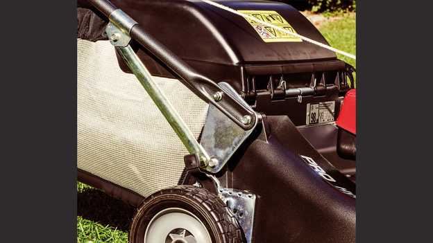 Gros plan du grand bac de ramassage de la tondeuse à gazon Honda HRD dans un jardin.