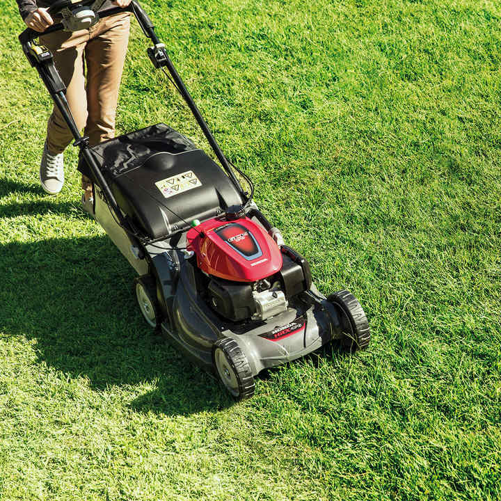 Tondeuse à gazon Honda HRX de trois quarts face dans un jardin.