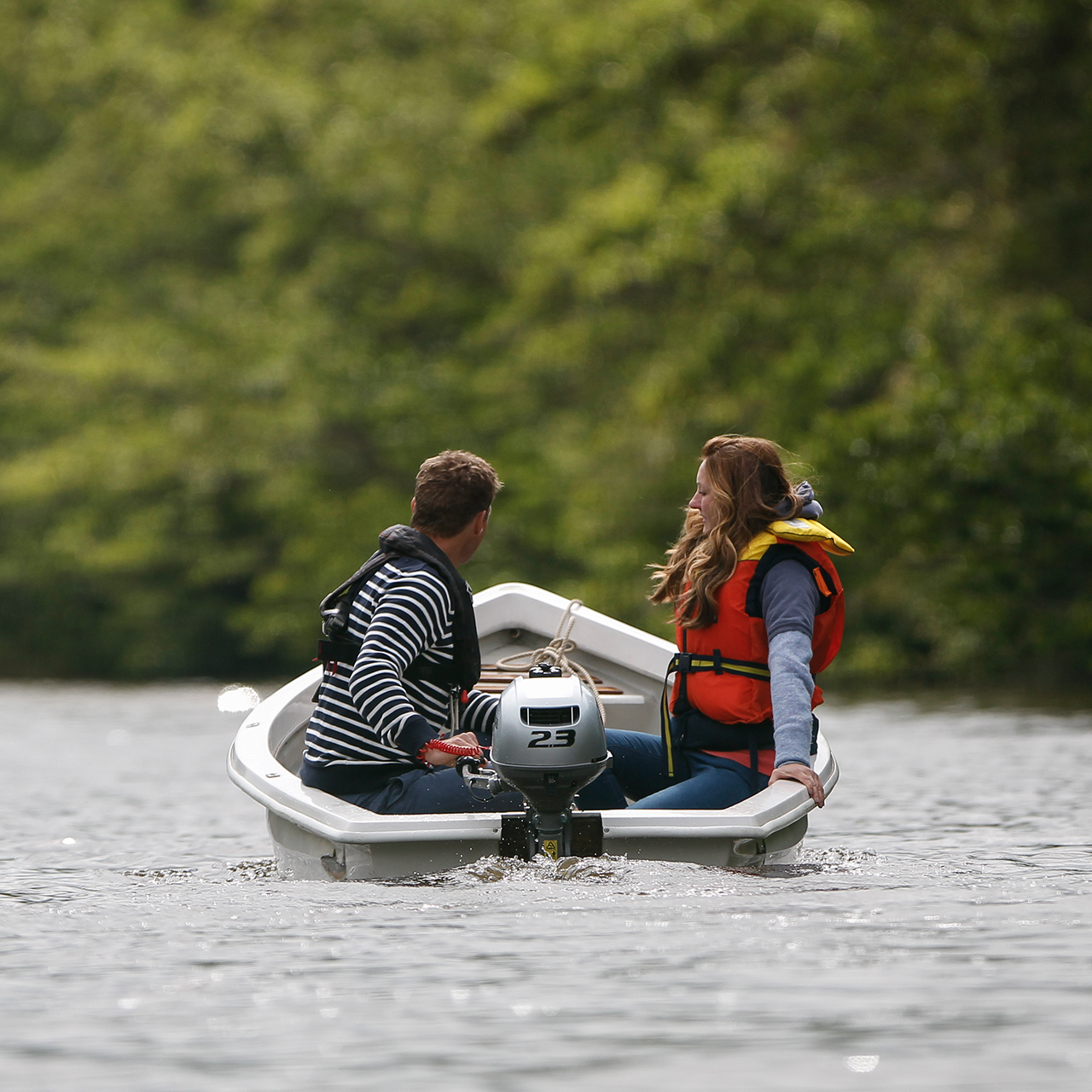 Deux personnes dans un bateau sur l'eau utilisant un moteur BF2.3.