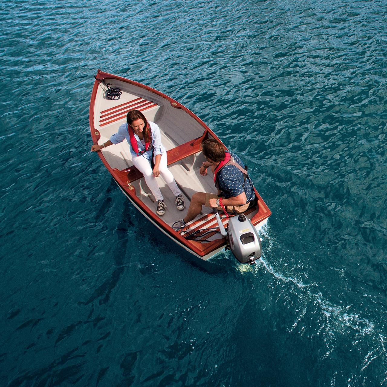 Couple sur un bateau équipé d'un moteur Honda sur l'eau.