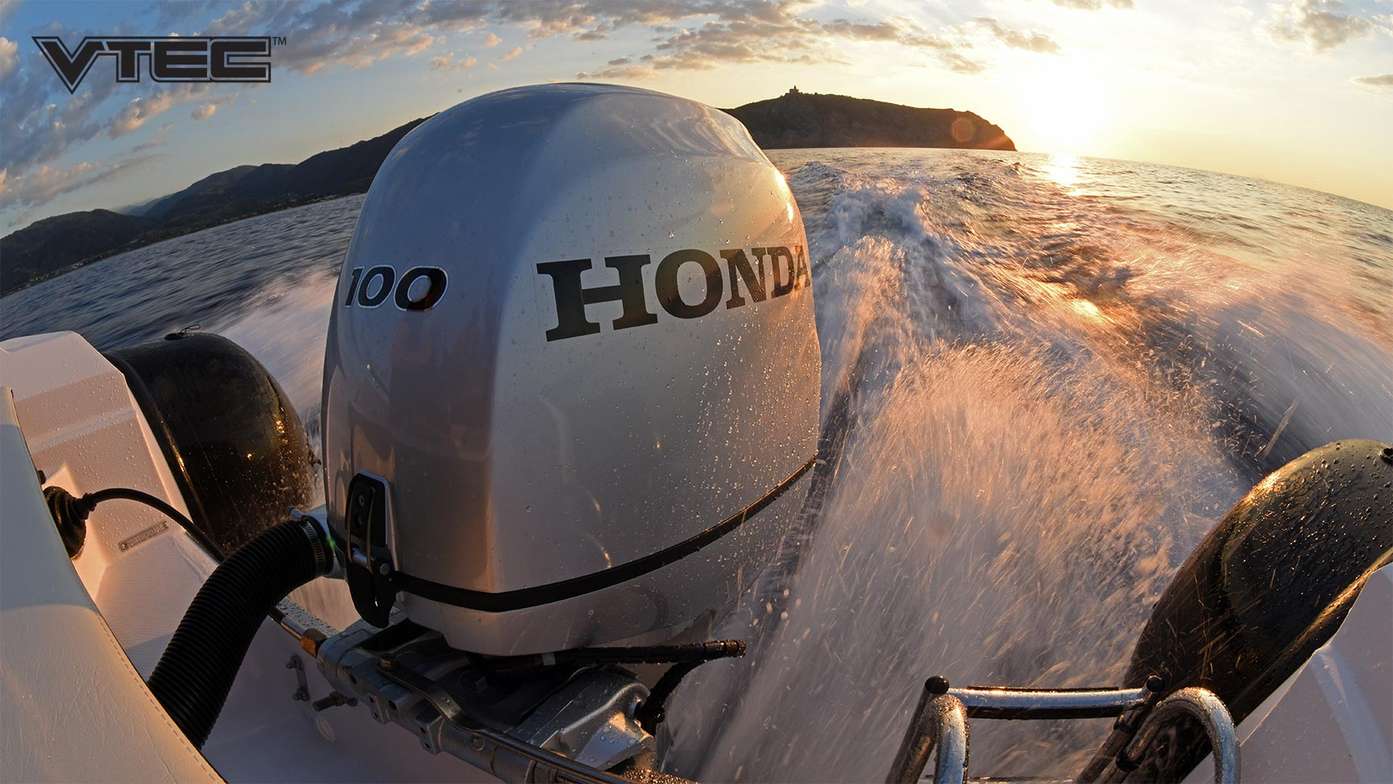 Coucher de soleil depuis l'arrière d'un bateau avec vue sur un moteur hors-bord Honda BF100
