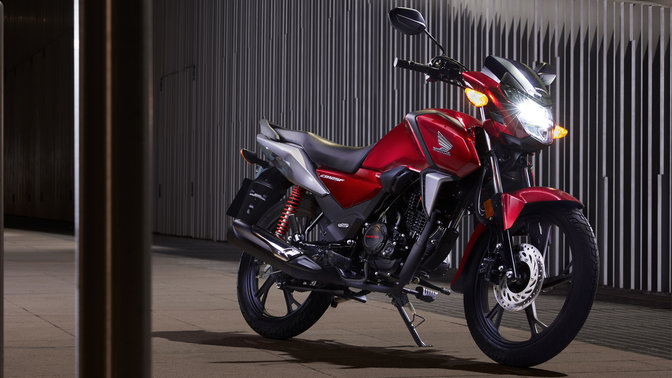 Moto 125 Honda CB125F rouge, prise dans un environnement urbain, de nuit