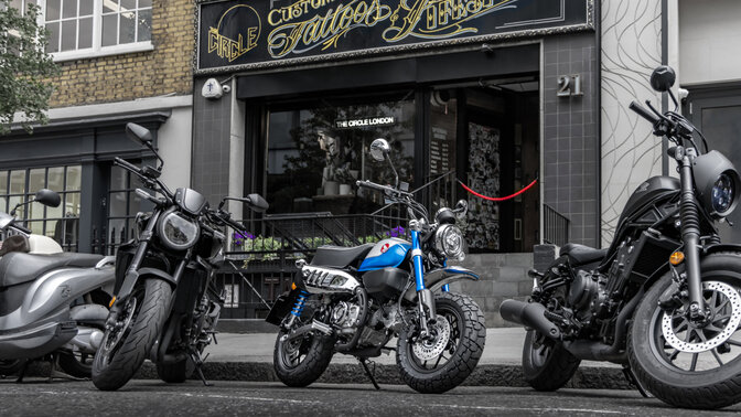 Honda Monkey sur béquille latérale sur une route avec pilote