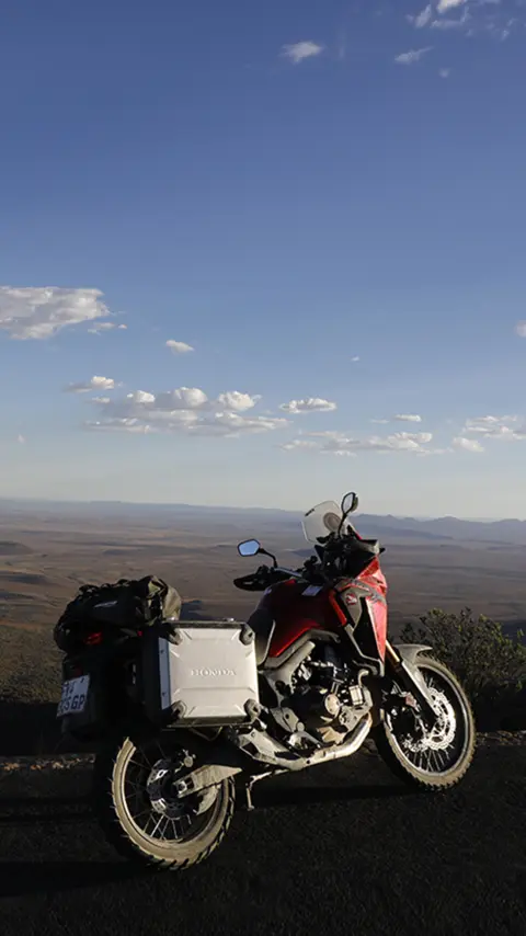 Honda CRF1000L Africa Twin stationné sur le bord de la route avec vue sur le désert du Karoo.