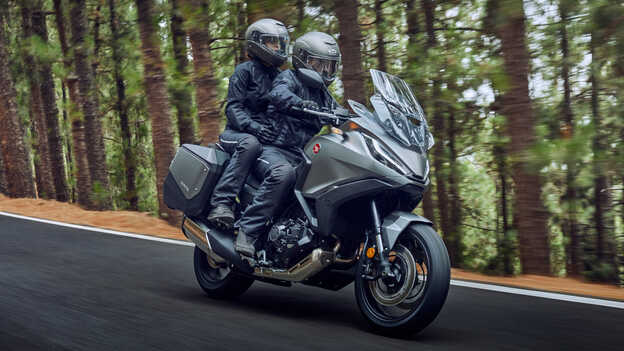 Vue de trois-quarts avant de la Honda NT1100 roulant dans une forêt