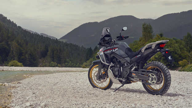 Pilote tenant la moto XL750 Transalp dans un endroit montagneux.