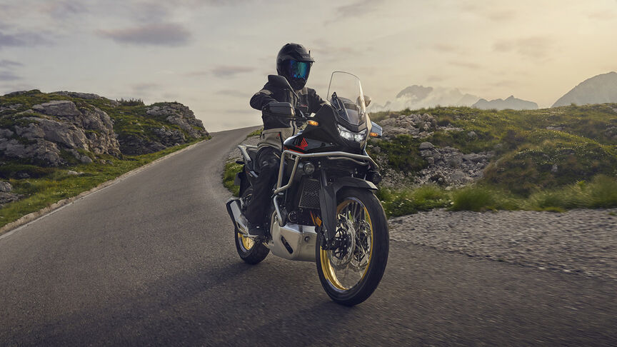 Mannequin conduisant la moto XL750 Transalp en forêt.