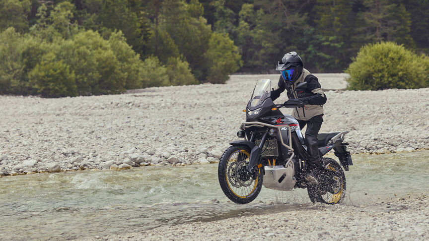 Mannequin conduisant la moto XL750 Transalp en forêt.