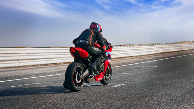 Mannequin sur une moto circulant sur piste de course.