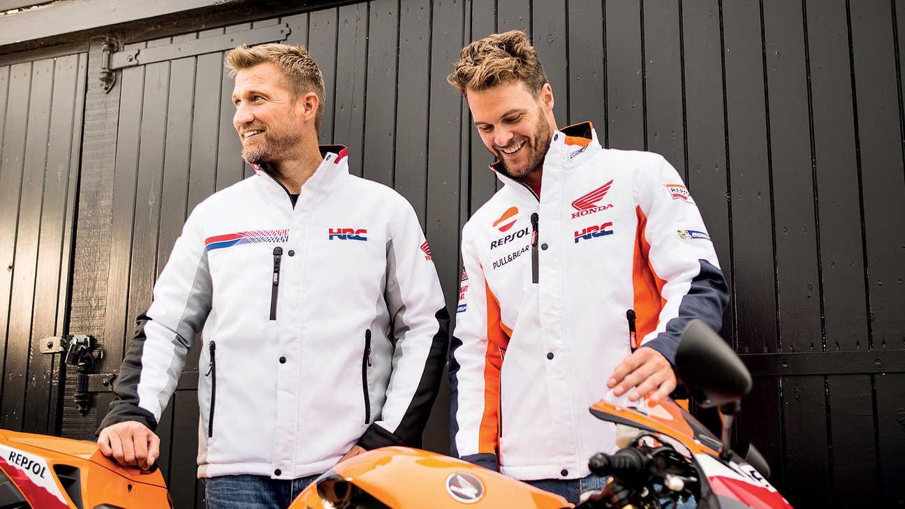 Deux hommes souriants portant des blousons de course Honda blancs