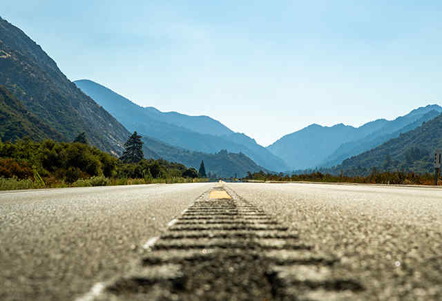 Route asphaltée déserte menant vers des montagnes