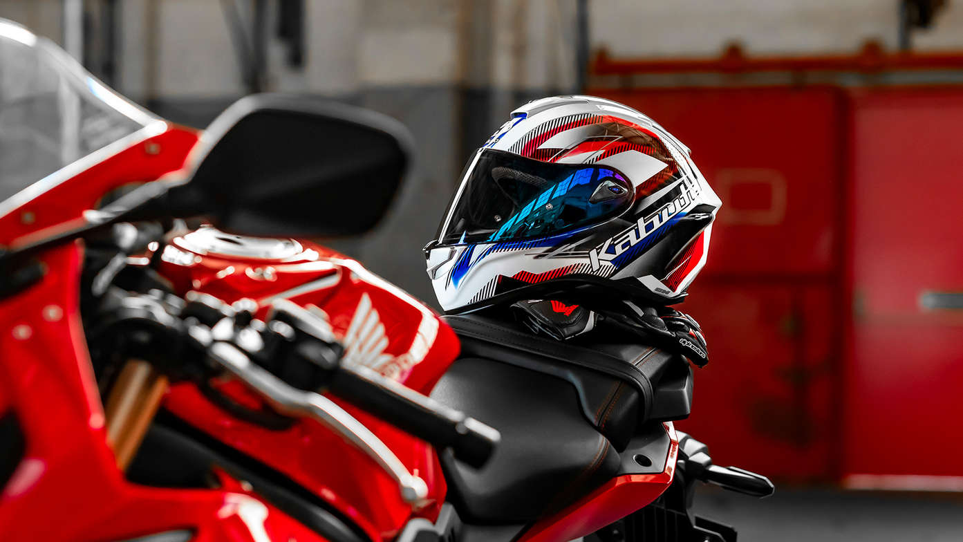 Casque Honda Kabuto, Aeroblade V - Go White Blue Red - CBR650, côté gauche, posé sur le réservoir d'une moto