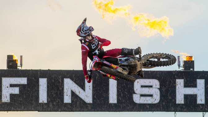 Pilote Honda de MXGP dans les airs sur la ligne d'arrivée.