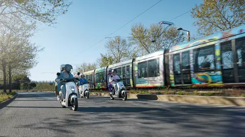 Honda EM1 e: roulant à côté d'un train