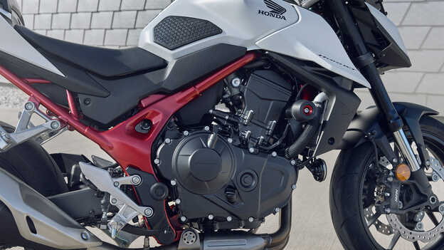 moto roadster streefighter Honda CB750 Hornet - permis A2 avec un homme adossé à un bâtiment.