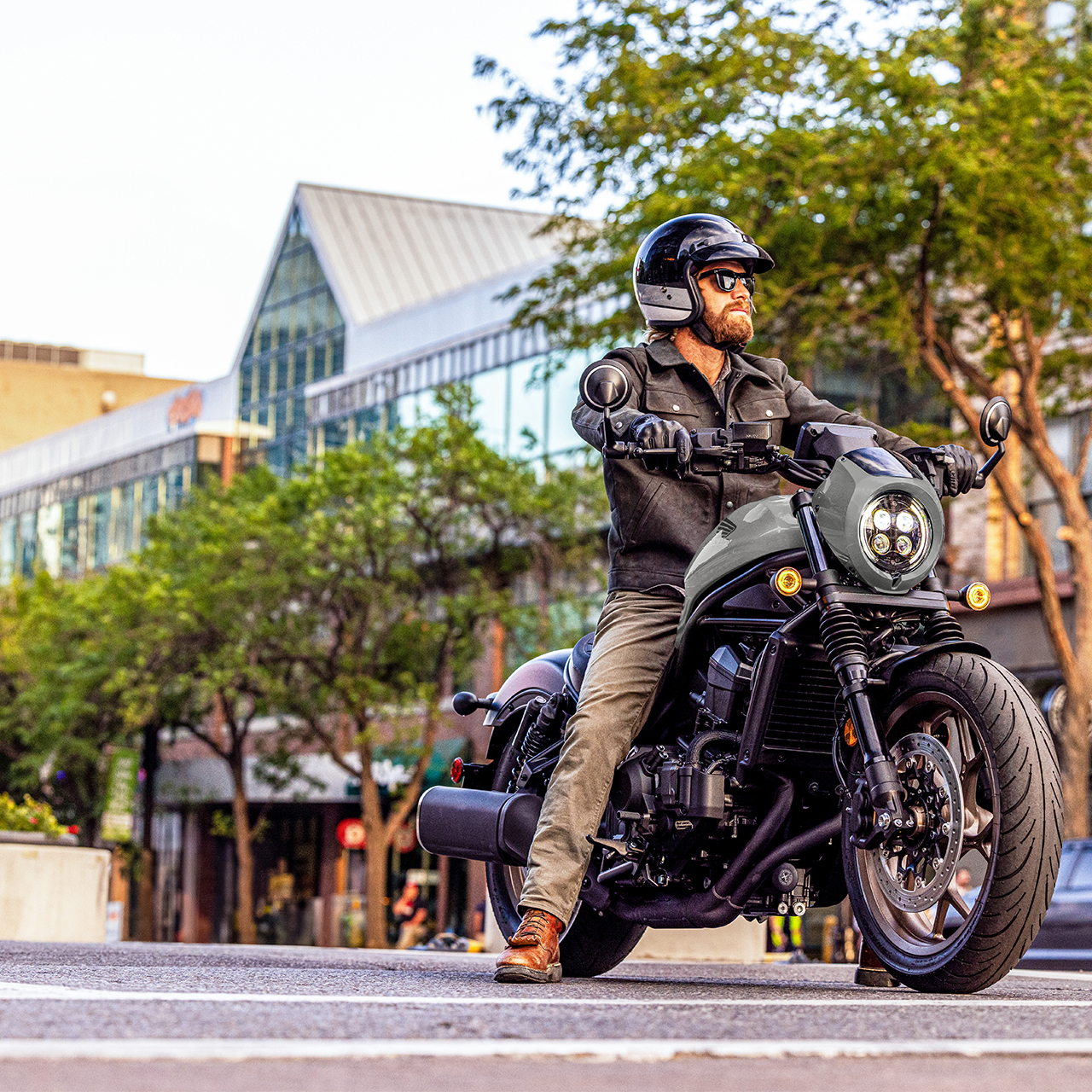 Personnage sur une Honda CMX1100 de face, en situation urbaine.