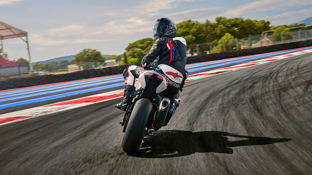 Vue latérale arrière de la Honda CBR1000RR-R Fireblade avec un pilote sur circuit