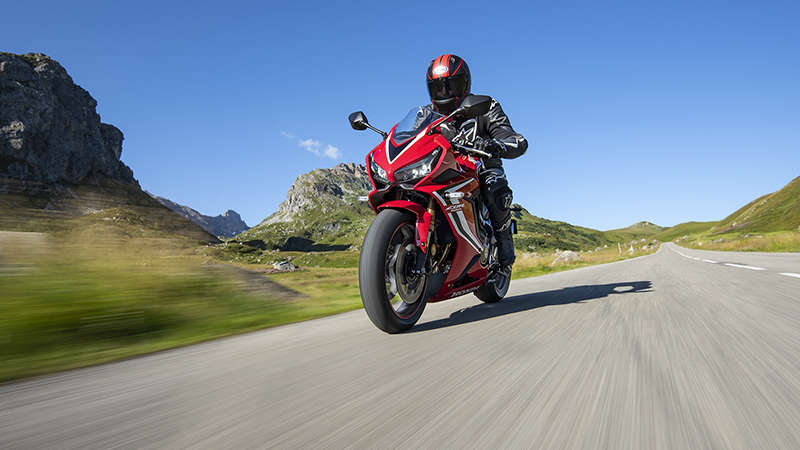 Vue de trois quarts avant gauche du roaster Honda Permis A2 CBR650R, pilotée sur une route de montagne