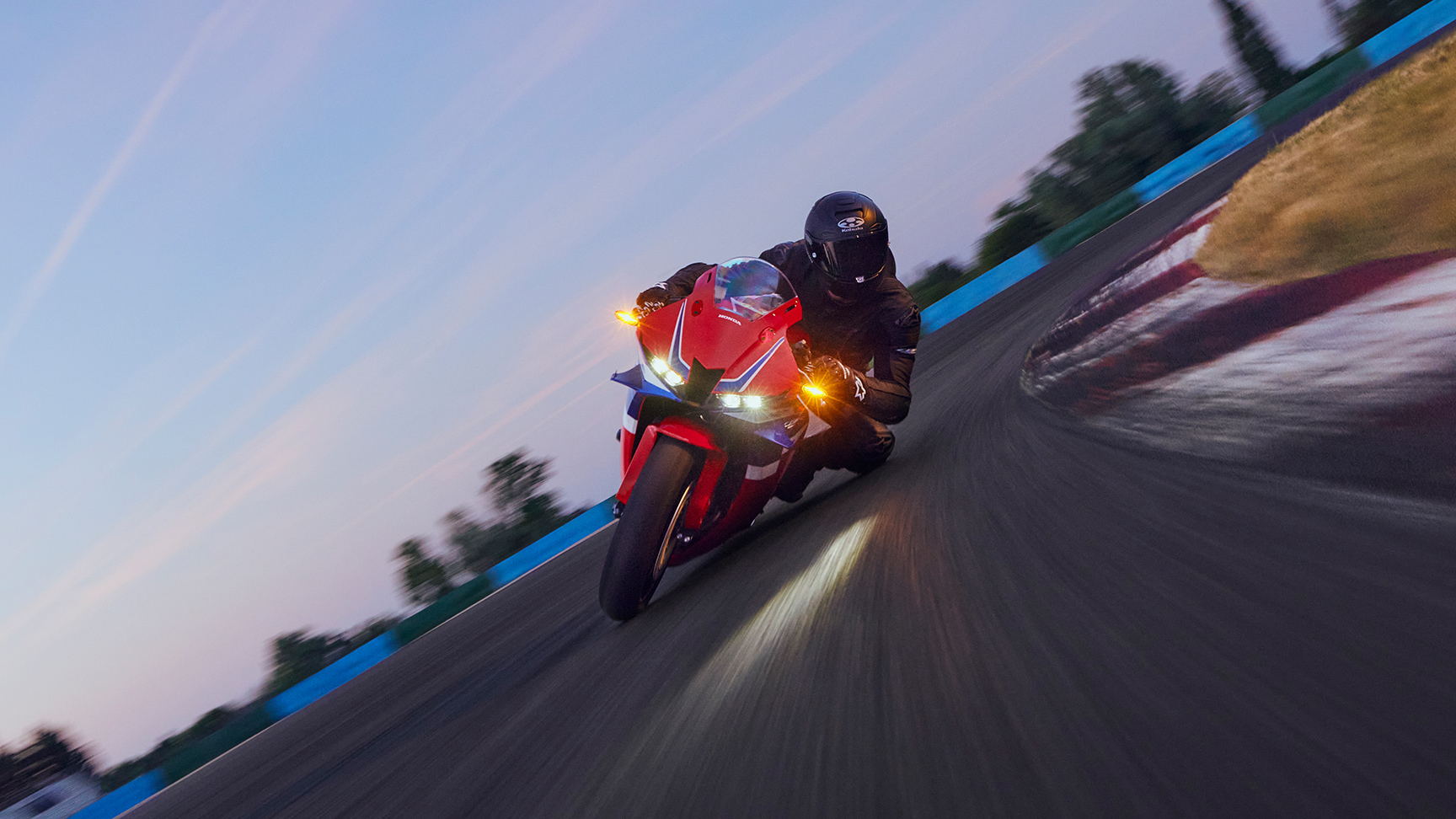 CBR600RR sur circuit avec motard dans un virage.