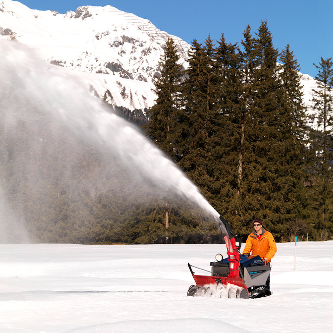 Fraise &agrave; neige Honda, utilis&eacute;e par un d&eacute;monstrateur, dans un lieu enneig&eacute;.