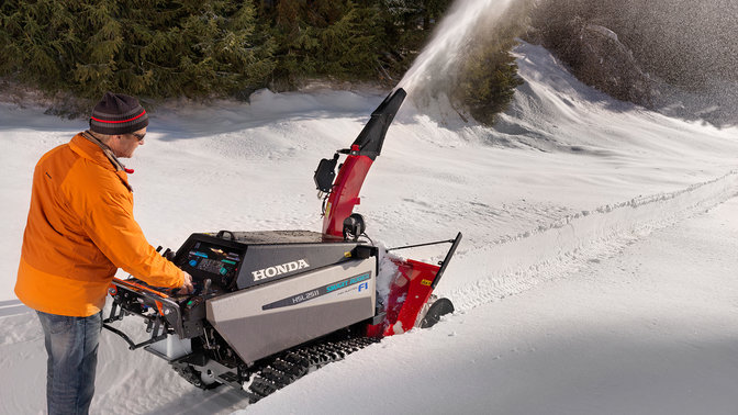 Fraise à neige Honda, utilisée par un démonstrateur, dans un lieu enneigé.