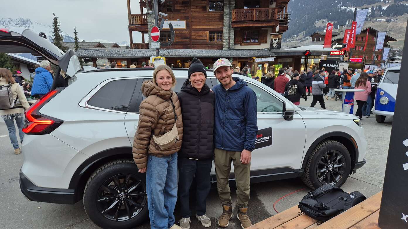 3 freeriders posant devant le Honda CR-V hybride au stand Honda à Verbier