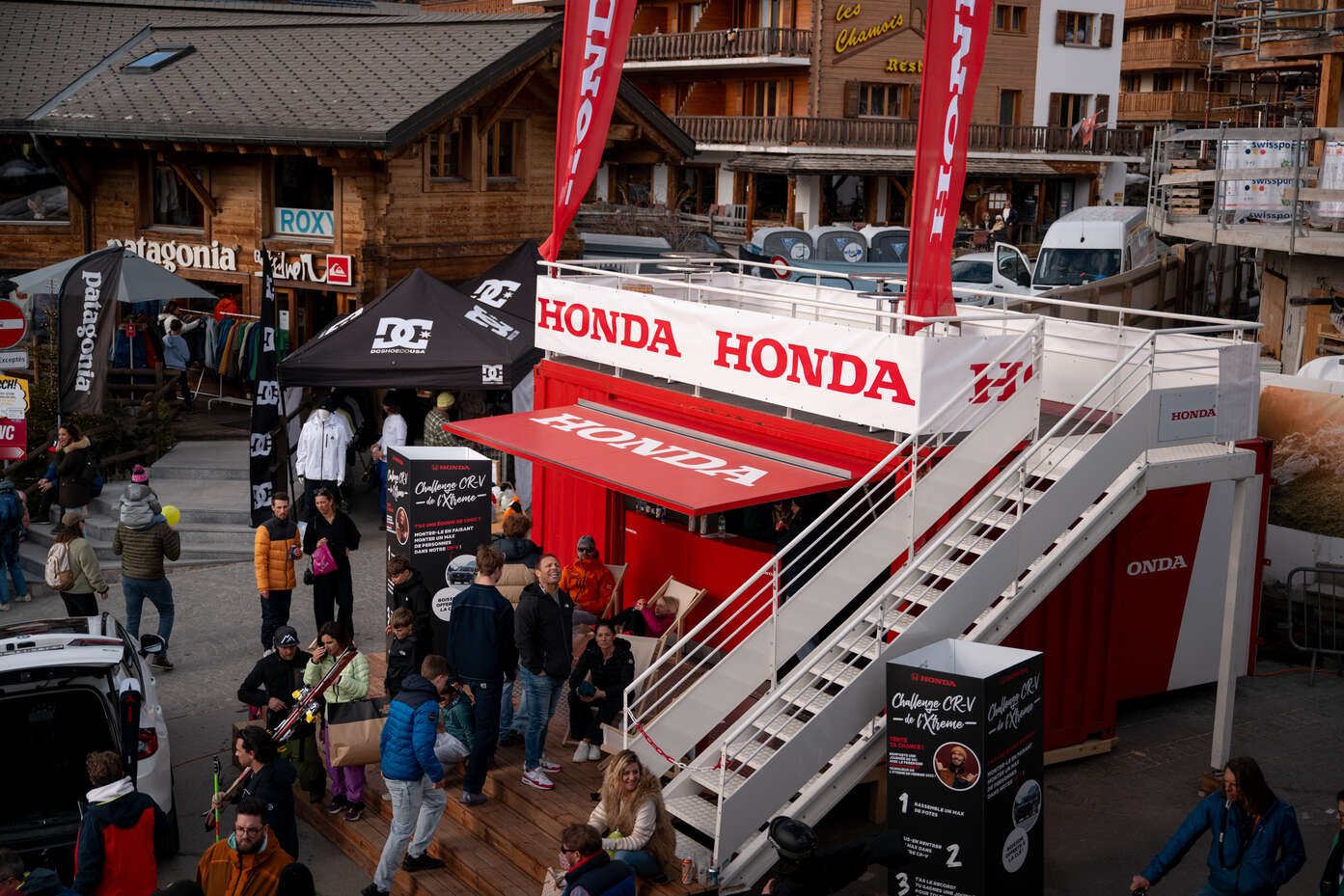 Stand Honda dans une ruelle à Verbier avec des gens autour