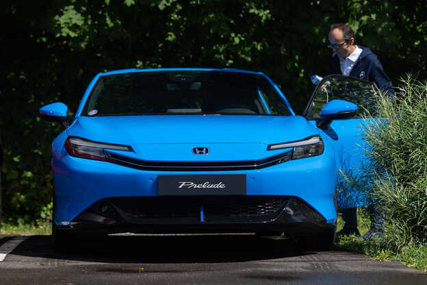 Honda Prelude bleue vue de face avec un homme ouvrant la portière côté conducteur