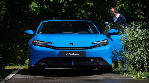 Honda Prelude bleue vue de face avec un homme ouvrant la portière côté conducteur