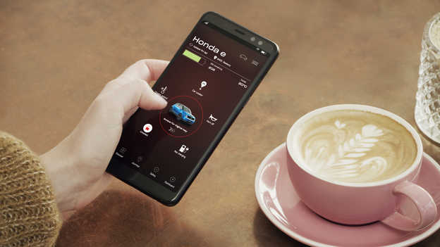 Une propriétaire d'une Honda utilise l'application My Honda+ sur son téléphone